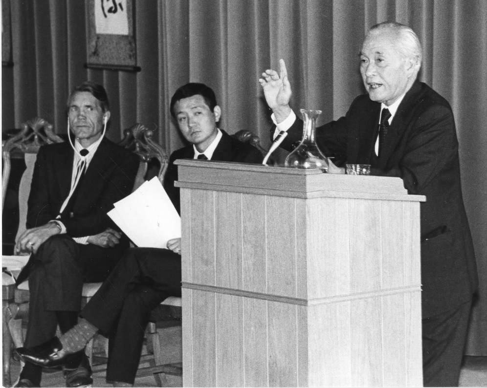 Minoru Takita speaking on platform